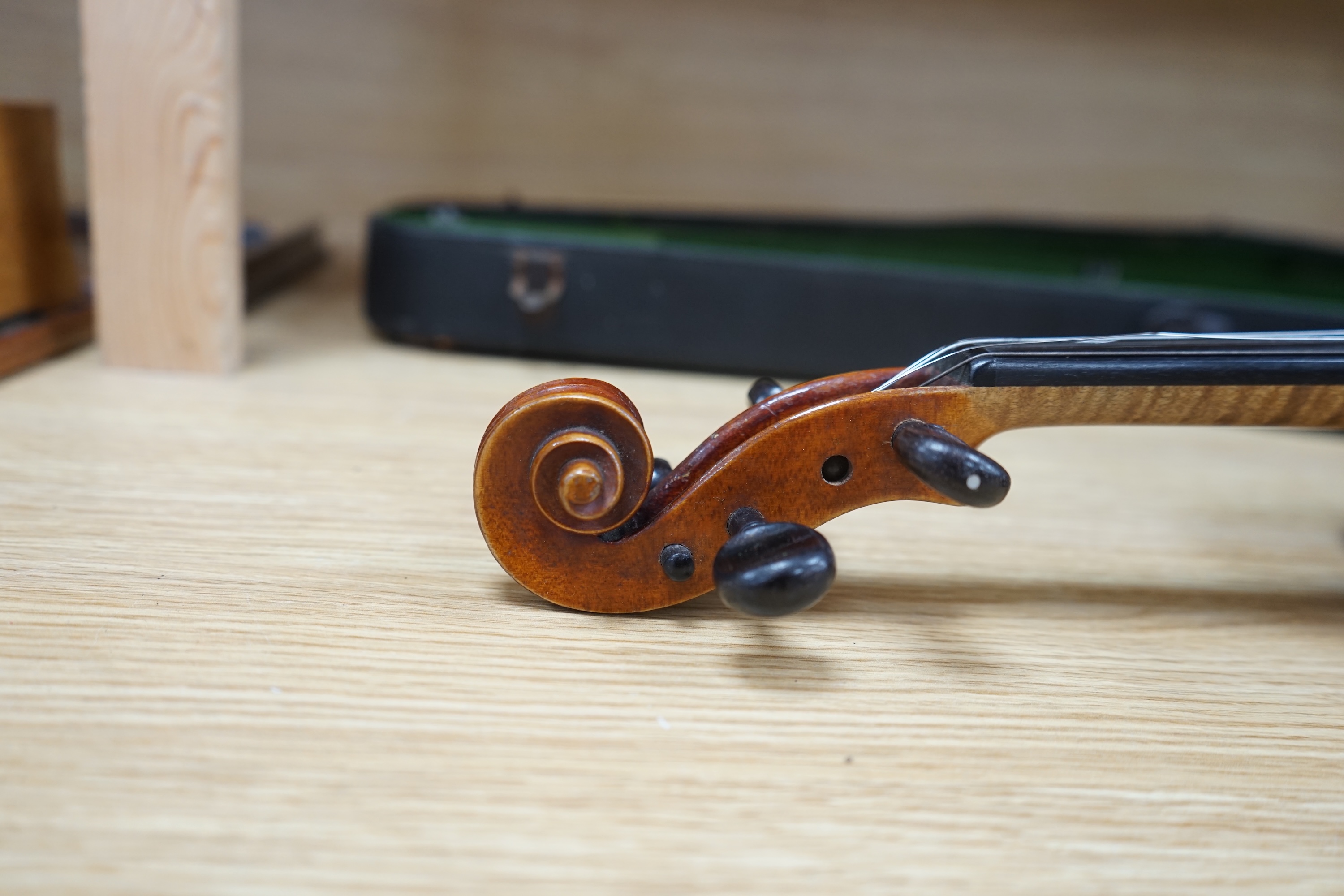 A cased early 20th century violin with bow, no label, back measures 35.5cm. Condition - fair to good